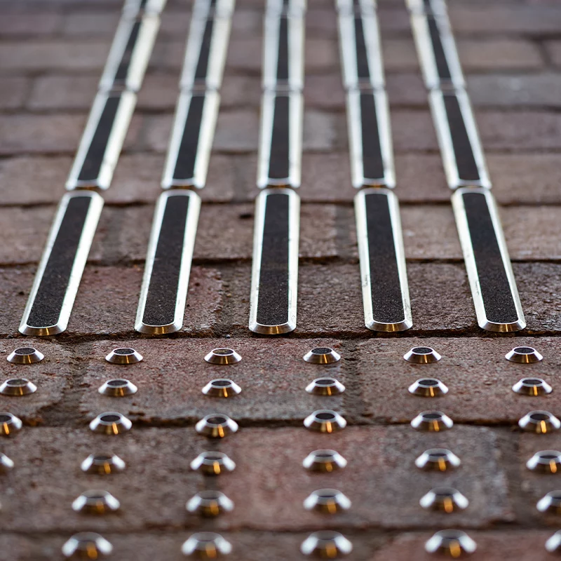 A close up of the start of a tackle guidance path featuring metal tactile studs and strips with anti slip inserts
